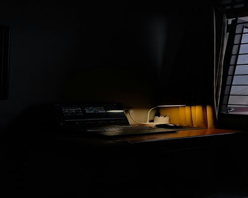 A laptop screen glowing in a dark room late at night